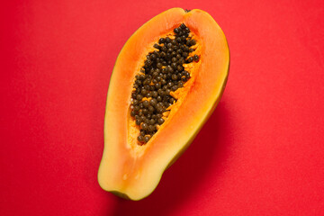 Papaya fruit on a orange background. Half papaya.