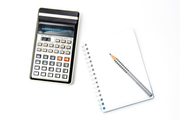 Calculator, pencil and notebook on white background. Close-up. Copy space