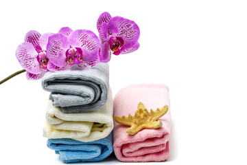 Obraz na płótnie Canvas Orchid flower, towels and starfish on white isolated background. Spa, relaxation concept