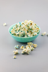Blue bowl with sweet popcorn, isolated on a gray background