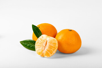 Orange colored mandarin and clementine fruits with green leaves isolated on white background.