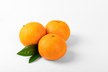 Orange colored mandarin and clementine fruits with green leaves isolated on white background.