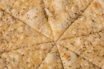 Focaccia pizza with cheese on white dish on a dark wooden table