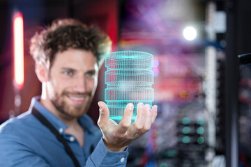 Male IT professional holding hologram of database in server room