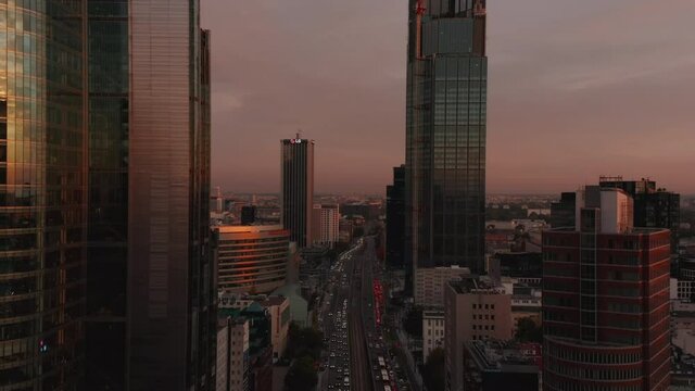 Descending footage of busy wide street leading between tall modern downtown skyscrapers. Warsaw, Poland