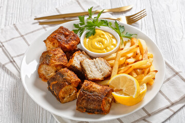fried pieces of hake on a plate with french fries