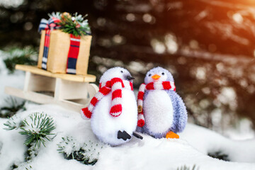 Christmas background-penguins carry a gift on a sled
