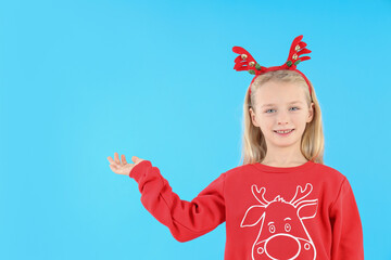 Little girl in Christmas clothes on blue background