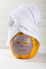 Pumpkins with face mask and towel on white background, with 