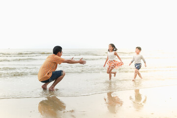 Fototapeta na wymiar asia family have fun together on the beach, travel the sea thailand