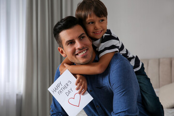 Little boy greeting his dad with Father's Day at home