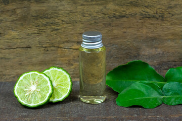 Bergamot oil in glass bottle and fresh bergamot fruit on rustic wooden background.
