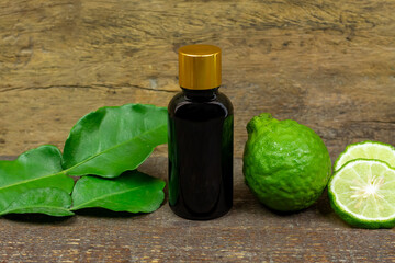 Bergamot oil in glass bottle and fresh bergamot fruit on rustic wooden background.