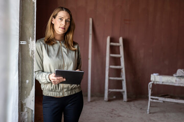 Female architect with digital tablet at construction site