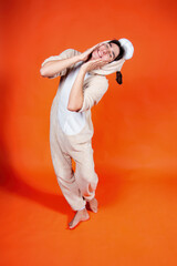 Surprised young man in pajamas on an orange background. Feelings and emotions.