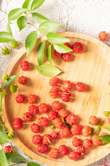 Pitangas placed on a wooden plate on a white plastic tablecloth on the table, selective focus.