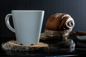 Closeup of traditional Finnish cinnamon rolls on top of wooden coasters. Cinnamon sticks.