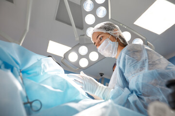Close-up of a female surgeon in an operating room, a doctor with a tense expression on his face, in an operating room.