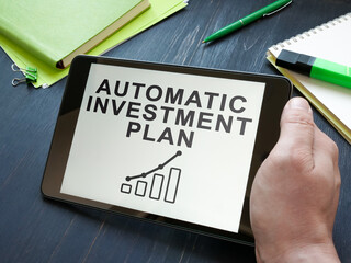 Man holds automatic investment plan AIP in the tablet.