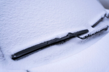 Snow-covered car windshield, wiper blade in fluffy First snow - obrazy, fototapety, plakaty