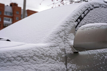 A snow-covered car, a car in the fluffy first snow, The beginning of winter, morning worries