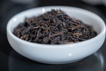 Selective focus closeup of a cup filled with fresh tea leaves.