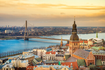 Panorama of the city of Riga on a sunny day, morning, sunset, a view of the old town, narrow streets, red brick roofs of houses, cathedrals, a river and bridge.