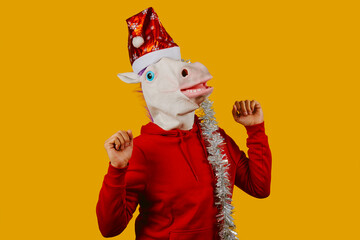 Fototapeta na wymiar man dancing wearing a unicorn mask and a santa hat