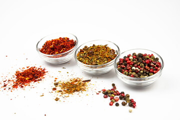Glass bowls with a variety of spices and seasonings isolated on a white background.