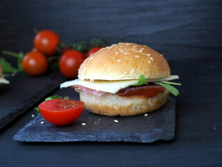 A sandwich with cheese and ham and fresh tomatoes. Isolated on black background