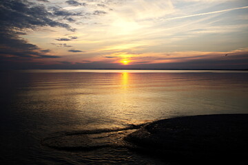 Fototapeta premium The sun setting over Sandbanks Provincial Park in Prince Edward County. The beaches and dunes attract tourists to this spot every year in Ontario, Canada.