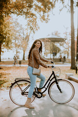 Young woman riding bicycle on autumn day
