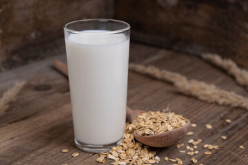 glass of vegetable oat milk on wooden background