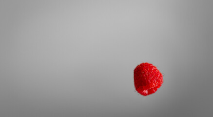Fresh raspberry on flat, neutral background with space for copy text