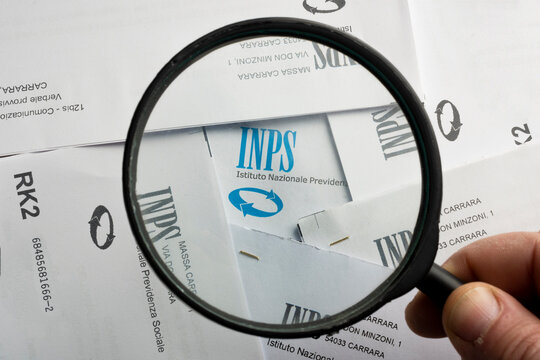 Man highlights the INPS (National Social Security Institute) logo with a magnifying glass
