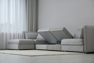 Modular sofa with storage near wall in living room. Interior design