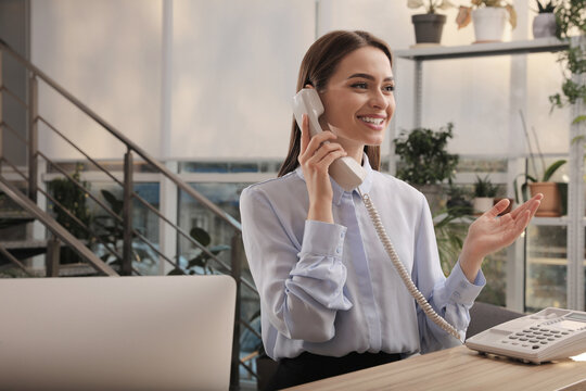 Female receptionist talking on phone at workplace