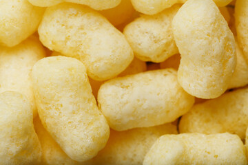Golden corn sticks in powdered sugar close-up.