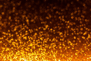 Holiday glowing backdrop. Defocused background with glitter. Blurred bokeh.