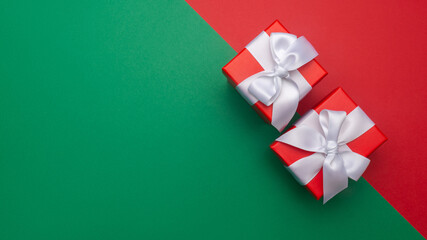 Celebratory red and green background with two gift boxes. Christmas background with copyspace. Holiday concept