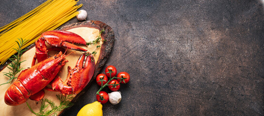 Cooked red lobster and pasta on dark background. Banner with copy space