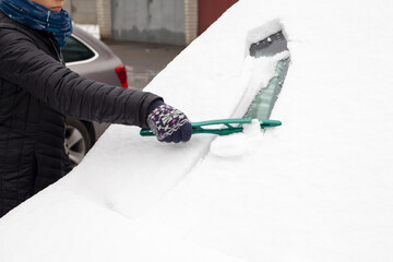 Zima, przykry i czasochłonny zimowy obowiązek odśnieżania auta - obrazy, fototapety, plakaty