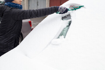 odśnieżanie zasypanego śniegiem auta 