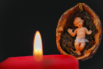 Jesukind, Christkind in Wallnuss mit Kerze.