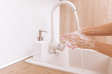 Washing hands under the flowing water tap. Hygiene concept hand detail. Washing hands rubbing with...