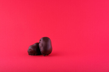 Two chocolates on a red background close-up photo