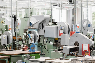 Different contemporary automated machine tools installed to process material and produce goods in light workshop of production plant