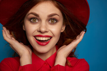 pretty woman wearing a red hat cosmetics posing blue background