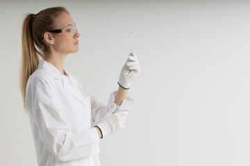 The girl laboratory assistant shows an indicator tube with the result of the analysis. Laboratory assistant in a medical laboratory or a petroleum product quality laboratory