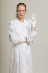 The girl laboratory assistant shows an indicator tube with the result of the analysis. Laboratory assistant in a medical laboratory or a petroleum product quality laboratory
